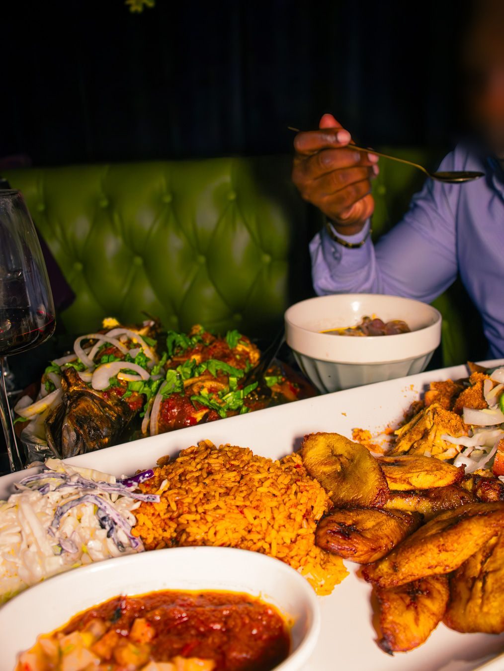 Jollof rice, plantain and grilled fish on a table